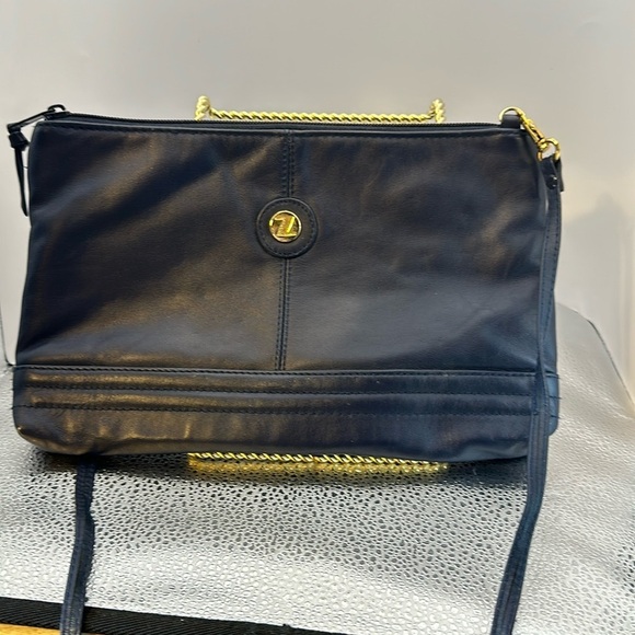 Crossbody dark blue with a Z emblem on the front but no markings on the bag.​​ - Picture 1 of 5
